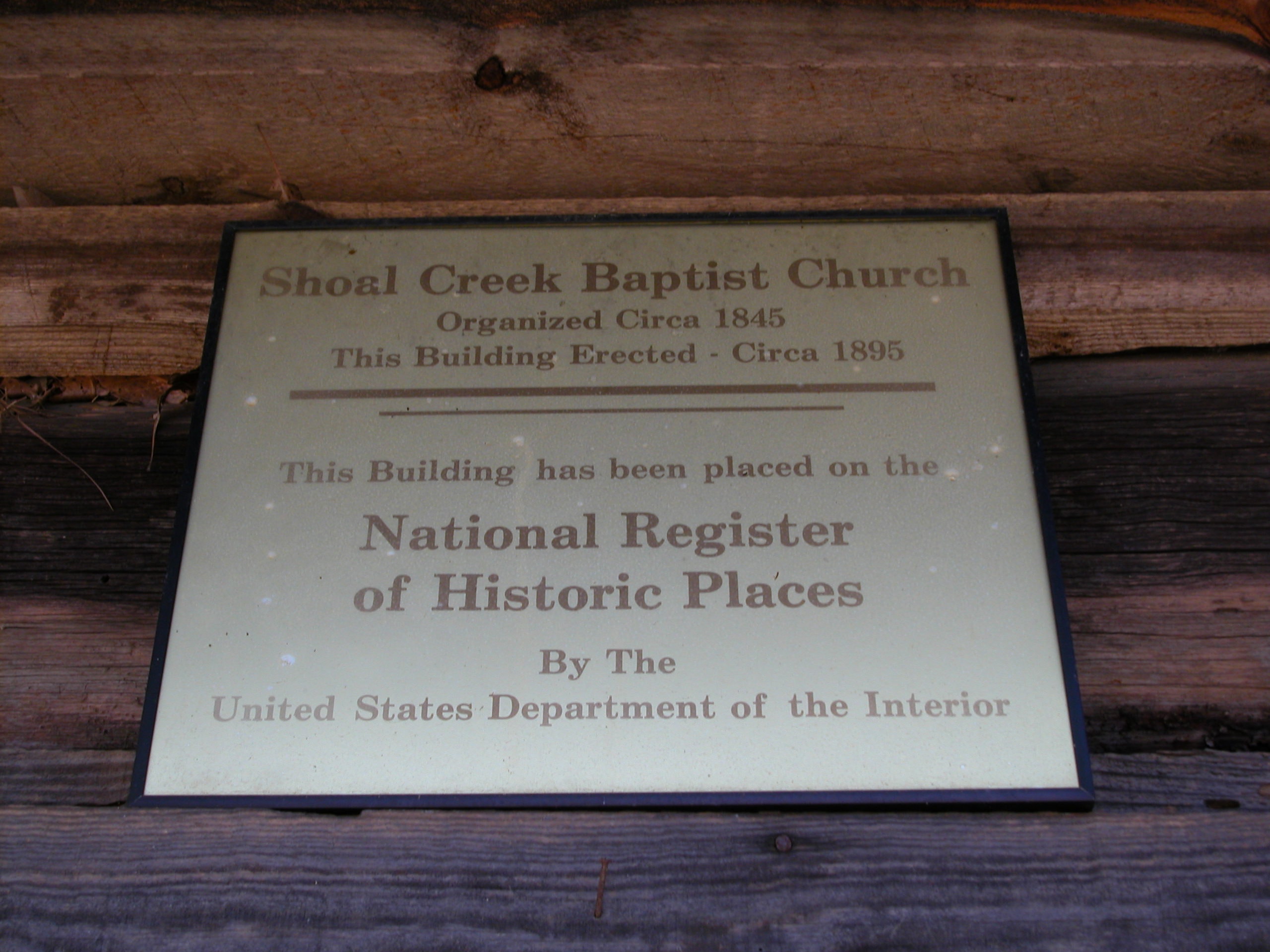 National Register of Historic Places plaque on the log wall.